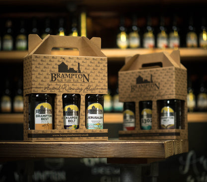 Two carton boxes of Brampton Brewery beer bottles on a bar counter with blurred background.