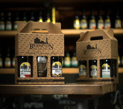 Two carton boxes of Brampton Brewery beer bottles on a bar shelf with blurred background.