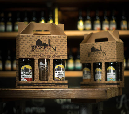 Two carton boxes of Brampton Brewery beer bottles on a wooden shelf with blurred brewery background.