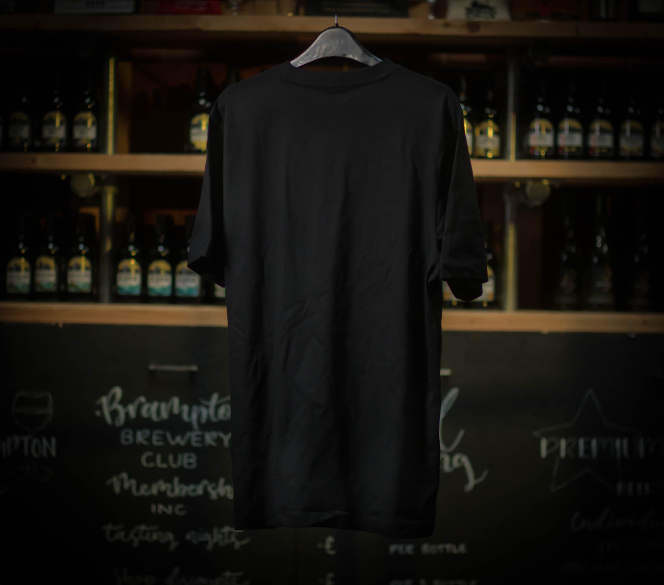 Black Brampton Brewery T‑shirt hanging in a rustic brewery setting.