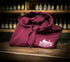 Folded maroon hoodie with a Brampton Brewery logo on a wooden surface with bottles in the background